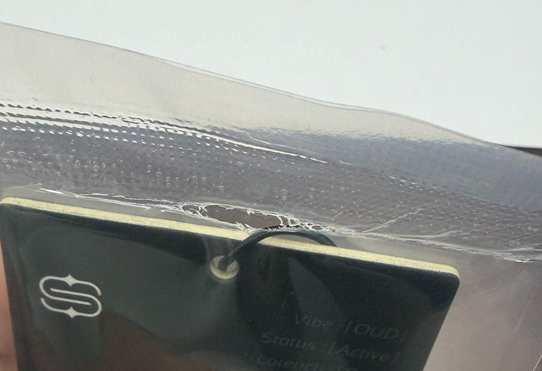 Close view of a sealed card: the elastic string is caught in the heat seal of the inner bag
